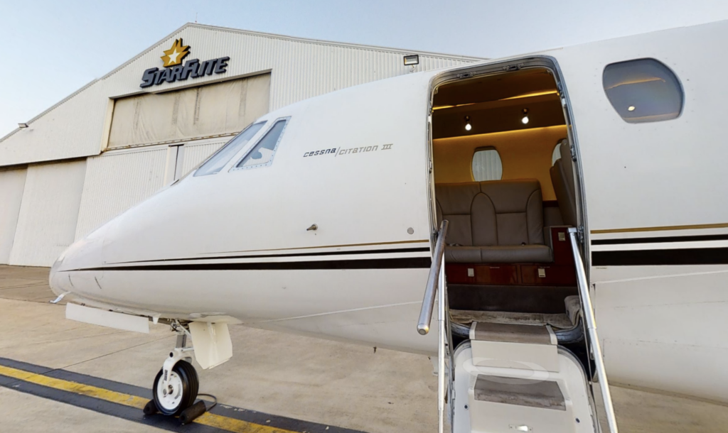 A small white airplane parked at an airport.