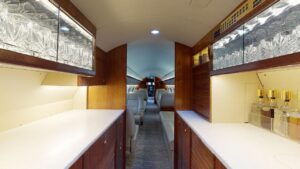 A long hallway with wooden cabinets and white counters.